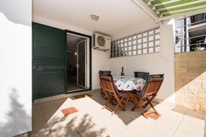 a patio with a table and chairs on a balcony at Apartment Pave by Zamalin beach in Tribunj
