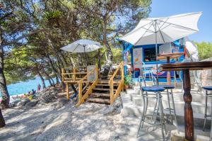 a food truck with chairs and umbrellas on the beach at Apartment Pave by Zamalin beach in Tribunj