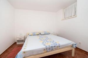 a bedroom with a bed in a white room at Apartment Pave by Zamalin beach in Tribunj
