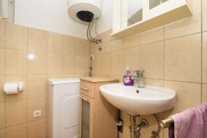 a bathroom with a sink and a washing machine at Apartment Pave by Zamalin beach in Tribunj +20 photos