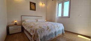 een witte slaapkamer met een bed en een raam bij Apartment Sea view in Vrboska
