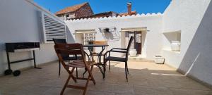 a patio with chairs and a table on a balcony at House Stone house Skor in Stari Grad