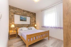 1 dormitorio con cama y pared de piedra en Apartment Luka, en Rupe