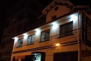 a building with lights on the side of it at night at Hostal Flores in La Paz