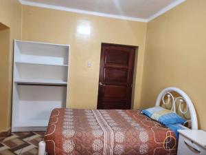 a bedroom with a bed and a wooden door at Hostal Flores in La Paz