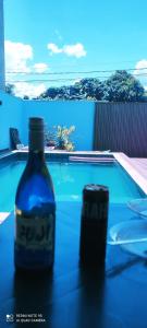 uma garrafa sentada numa mesa ao lado de uma piscina em Recanto Matheus Morotti MM em Maringá