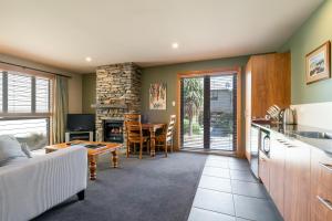 a kitchen and living room with a couch and a table at Wanaka Luxury Apartments in Wanaka