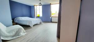a blue room with two beds and a window at Maison accueillante à Saint-Amand-en-Puisaye avec jardin in Saint-Amand-en-Puisaye