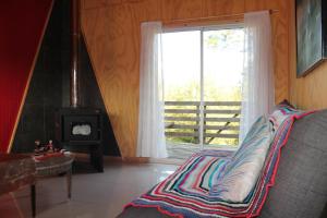 a bedroom with a bed with a window and a stove at El Rincon de la Olguita in Curacautín