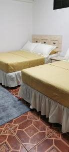 three beds are lined up in a room at APARTAMENTOS CASCO HISTORICO COMAYAGUA in Comayagua