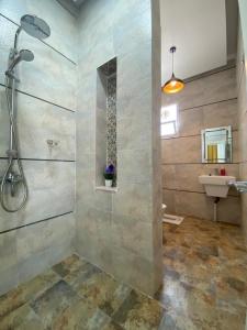 a bathroom with a shower and a sink at فيلا تل الورد in Ibri