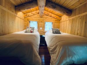 una camera con 2 letti in una baita di tronchi di Artemis Log Cabin with Spa & Mountain View a Sainte-Lucie-de-Doncaster