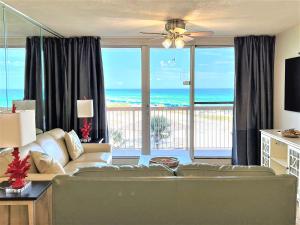 a living room with a couch and a view of the ocean at Pelican Beach 2 bedroom 4th floor Gulf Front Condo in Destin