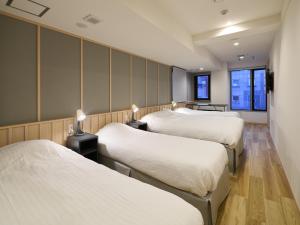 Tempat tidur dalam kamar di Shinjuku City Hotel N.U.T.S Tokyo