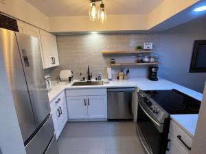 a kitchen with white cabinets and a stainless steel refrigerator at Next to Lake, Pool, 10 Acre Park, 1 Mile to Town, Best Prices in Chelan