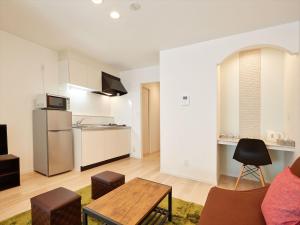 a living room with a table and a kitchen at Condominium・yuyuki in Yomitan