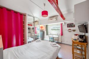 a bedroom with pink curtains and a bed and a table at Studio sur Peniche, Le Cormoran, Bord De Saone A Lyon in Lyon