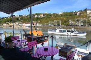 a boat on the water with purple tables and chairs at Studio sur Peniche, Le Cormoran, Bord De Saone A Lyon in Lyon