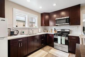 a kitchen with wooden cabinets and a stove top oven at Oceanside Rocks Family Vacation Home in Oceanside