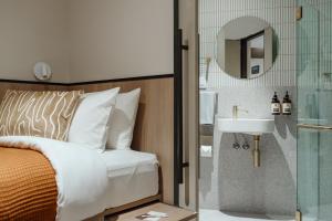 a bedroom with a bed and a sink and a mirror at Aerotel Sydney (Arrivals B, International Terminal 1) in Sydney