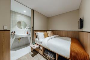 um quarto com uma cama, um lavatório e um chuveiro em Aerotel Sydney (Arrivals B, International Terminal 1) em Sydney
