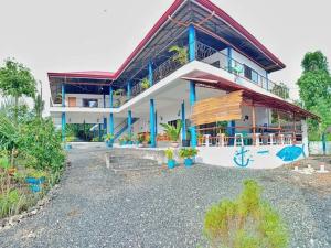 a large house with blue columns and a roof at Happy Bear in Moalboal