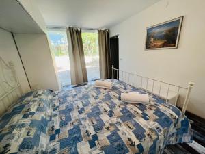 a bedroom with a bed with a blue and white quilt at Villa Amedea in Lignano Sabbiadoro