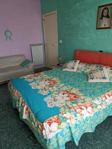 a bedroom with a bed with a floral quilt on it at Bed fiorella in Acciaroli