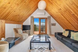un soggiorno con un divano e un tavolo di Alcheringa Cottage Amazing Location with views a Kangaroo Valley