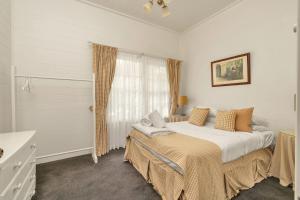 a bedroom with a bed and a window at Alcheringa Cottage Amazing Location with views in Kangaroo Valley