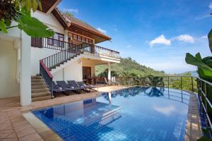 a villa with a swimming pool and a house at Heavenly Villas in Patong Beach