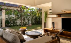 a living room with a couch and a tv at Bisma Eight Villas in Ubud