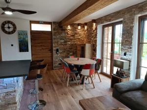 uma sala de estar com mesa e cadeiras em Luxus Ferienwohnung Chalet Seenähe em Schalkenmehren