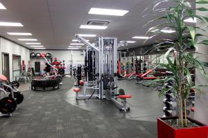 une salle de sport avec beaucoup d'équipements et de plantes dans l'établissement Oamaru Motor Lodge, à Oamaru