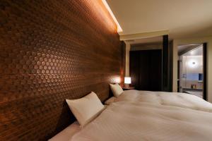 a bedroom with a large bed and a brick wall at Kyojuku Usagi - Vacation STAY 46044v in Kyoto