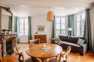 uma sala de estar com uma mesa e um sofá em Hypolite 1 New - Cocooning flat - 80 meters from the Port of Honfleur em Honfleur