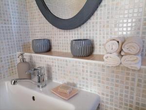 a bathroom with a sink and a mirror and towels at Lankás Vendégház - Hollókő in Hollókő