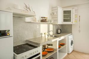 a white kitchen with a stove and a sink at Anatoli in Ambelas