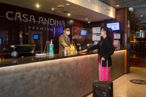 une femme debout dans un bar avec ses bagages dans l'établissement Casa Andina Premium Miraflores, à Lima