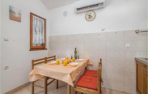 a dining room table with chairs and a bottle of wine at Nice Apartment In Bascanska Draga With Wifi in Draga Bašćanska
