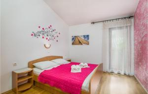 a bedroom with a pink bed with towels on it at Nice Apartment In Bascanska Draga With Wifi in Draga Bašćanska