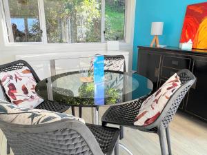 une table et des chaises en verre dans une pièce dans l'établissement Tiri Cottage - Sea Views in Oneroa by Waiheke Unlimited, à Oneroa 12 autres photos