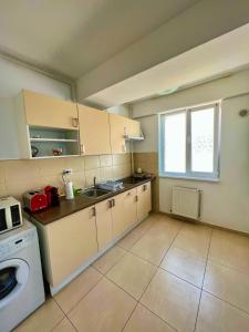 a kitchen with a sink and a washing machine at Scoica Alba Mamaia Nord Summerland in Mamaia