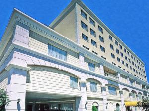 ein großes weißes Gebäude mit vielen Fenstern in der Unterkunft Hotel Monarque Tottori in Tottori