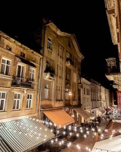 リヴィウにあるКвартира в центрі на вулиці Староєврейській 15а біля наливок Львоваの夜の灯りと建物が並ぶ街道