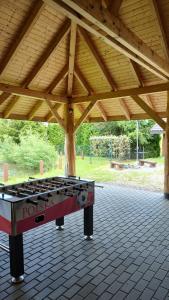 a ping pong table sitting under a wooden roof at Domki Żaklin in Berezka +3 photos