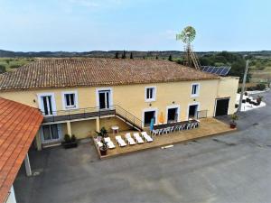 budynek z dużą ilością krzeseł i palmą w obiekcie Grande maison familiale avec piscine couverte w mieście Lespignan