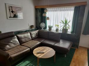a living room with a leather couch and a table at Ferienwohnung "Am Stadtpark" in Treuenbrietzen