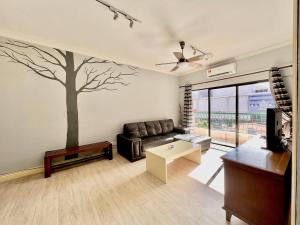 a living room with a tree mural on the wall at MARINA COURT VACATION HOME 3 BEDROOMS - Kota Kinabalu in Kota Kinabalu