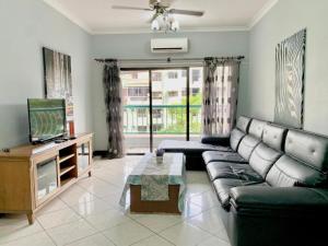 a living room with a couch and a tv at MARINA COURT VACATION HOME 3 BEDROOMS - Kota Kinabalu in Kota Kinabalu